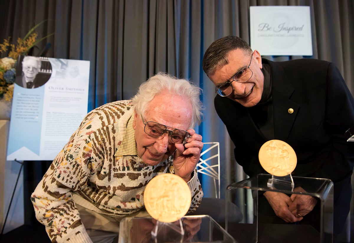 Oliver Smithes and Aziz Sancar look at their Nobel Prize Medals.