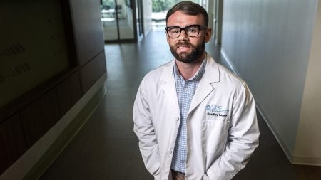 Medical student Bradley Lauck posing for portrait in white coat.
