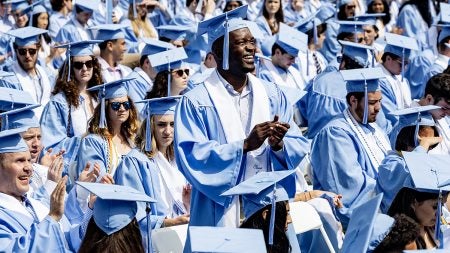 Students standing and clapping at Commencement
