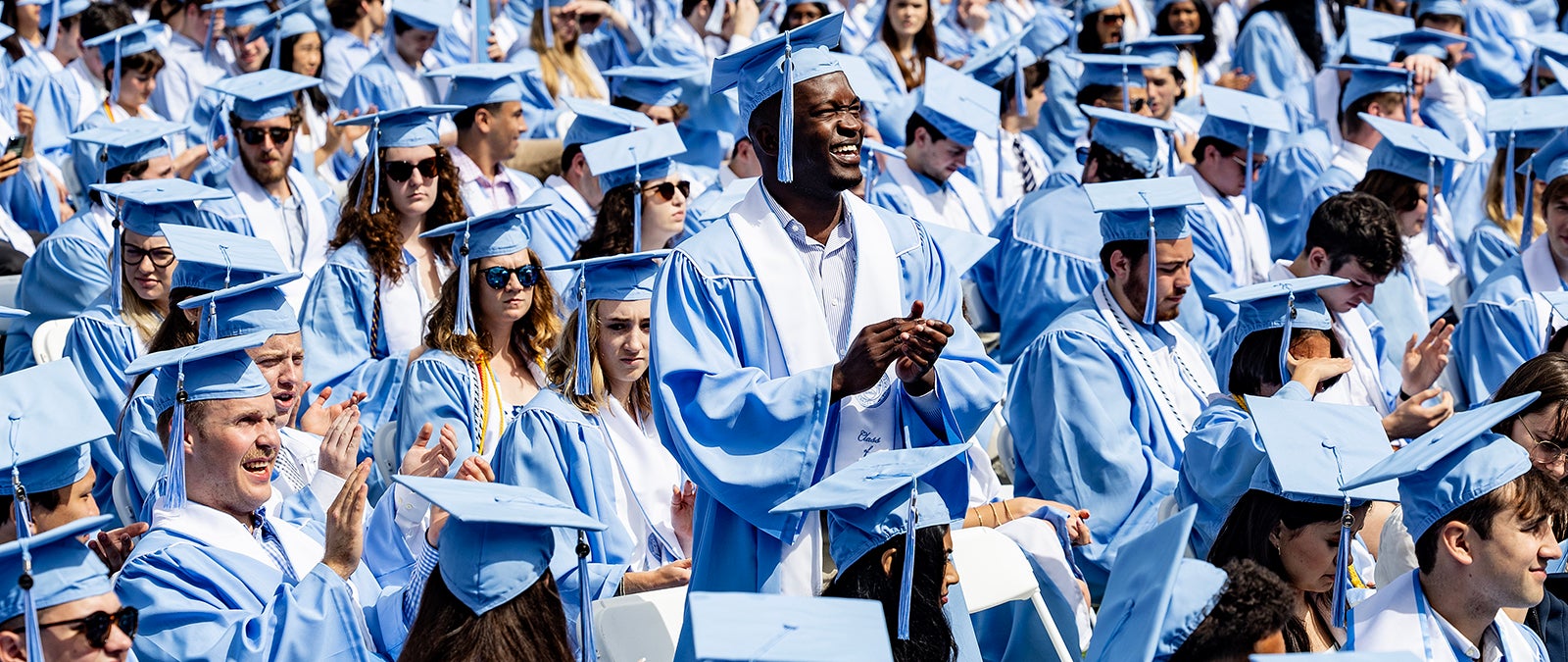 Students standing and clapping at Commencement