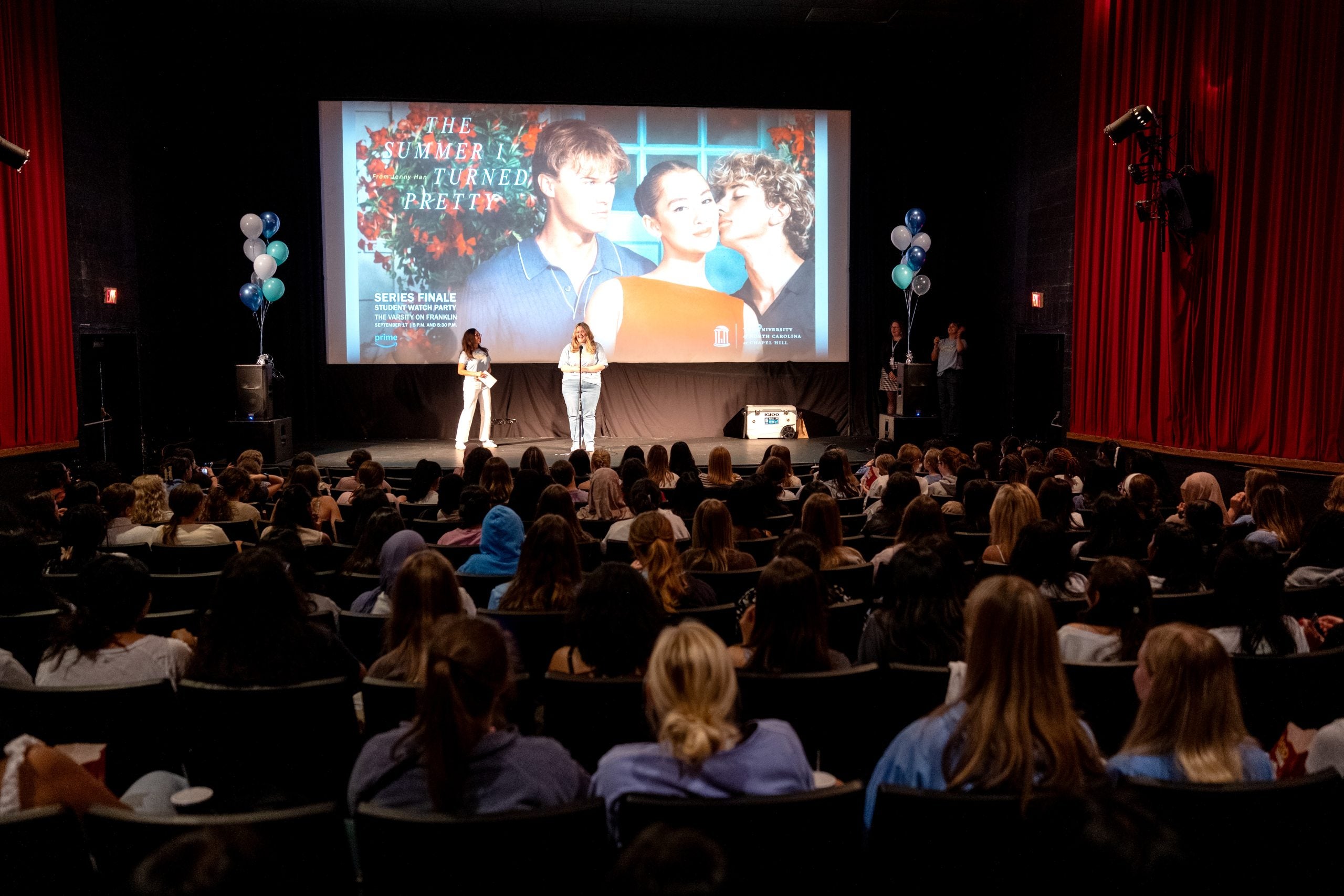 Students listen to speakers on stage at the Varsity Theatre before "The Summer I Turned Pretty" watch party.