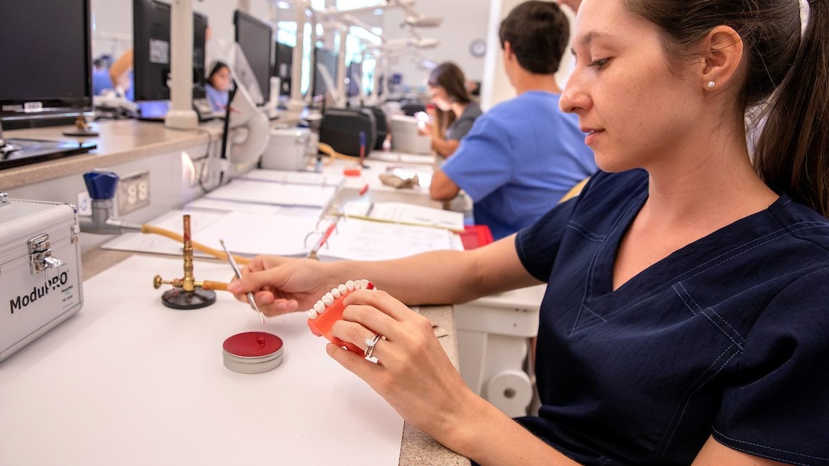 A dental student works in a lab.