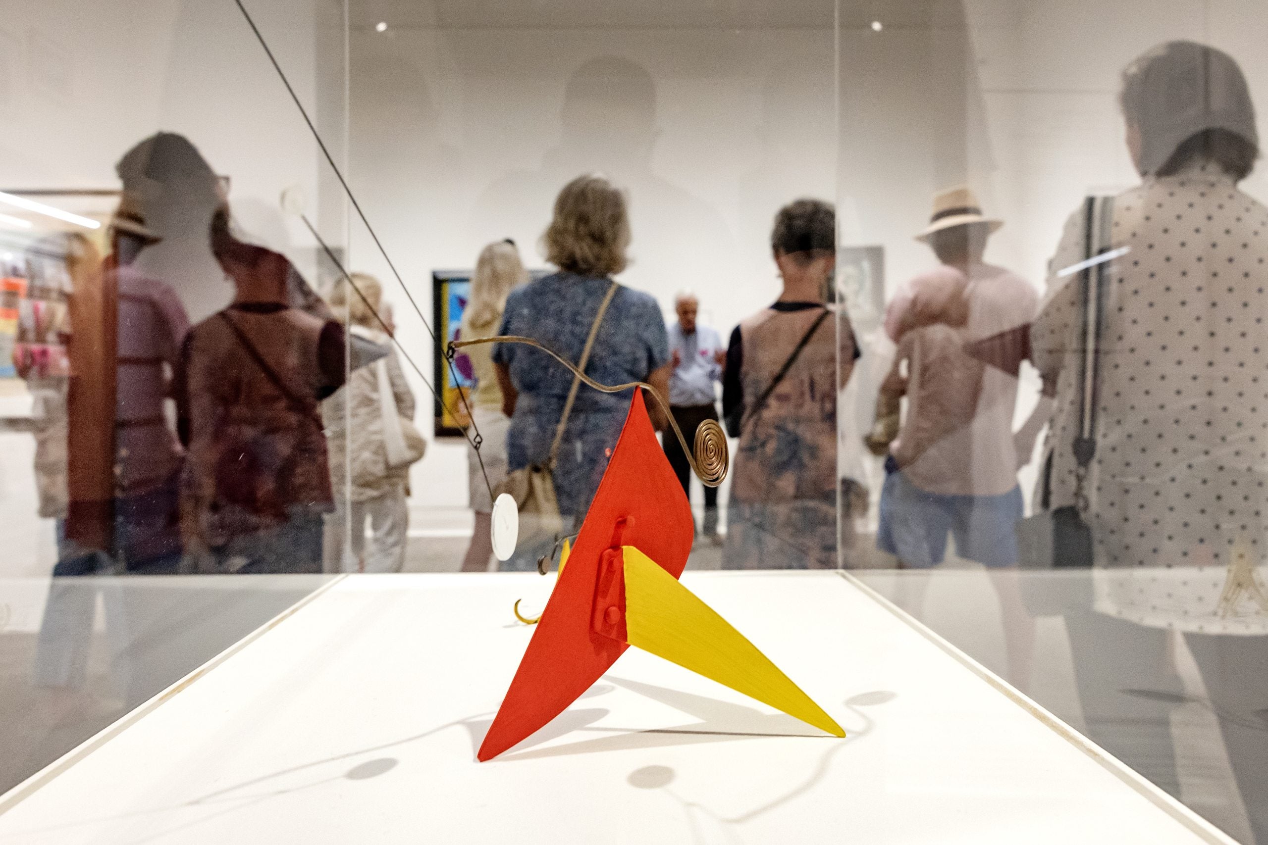 A sculpture in the foreground surrounded by visitors.