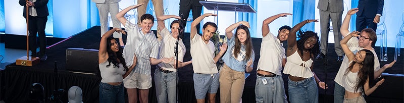 UNC-Chapel Hill student a cappella group Tar Heel Voices performing at New Student Convocation and using their bodies to spell out "C" for "Carolina."