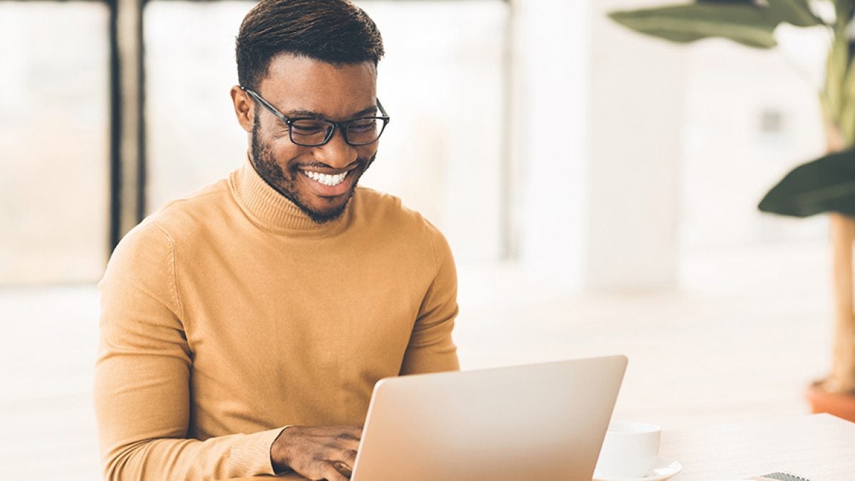 A man types on a laptop.