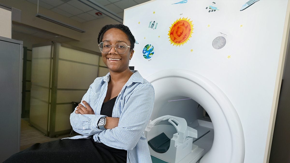 Adrienne Bonar posing next to MRI machine.