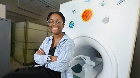 Adrienne Bonar posing next to MRI machine.