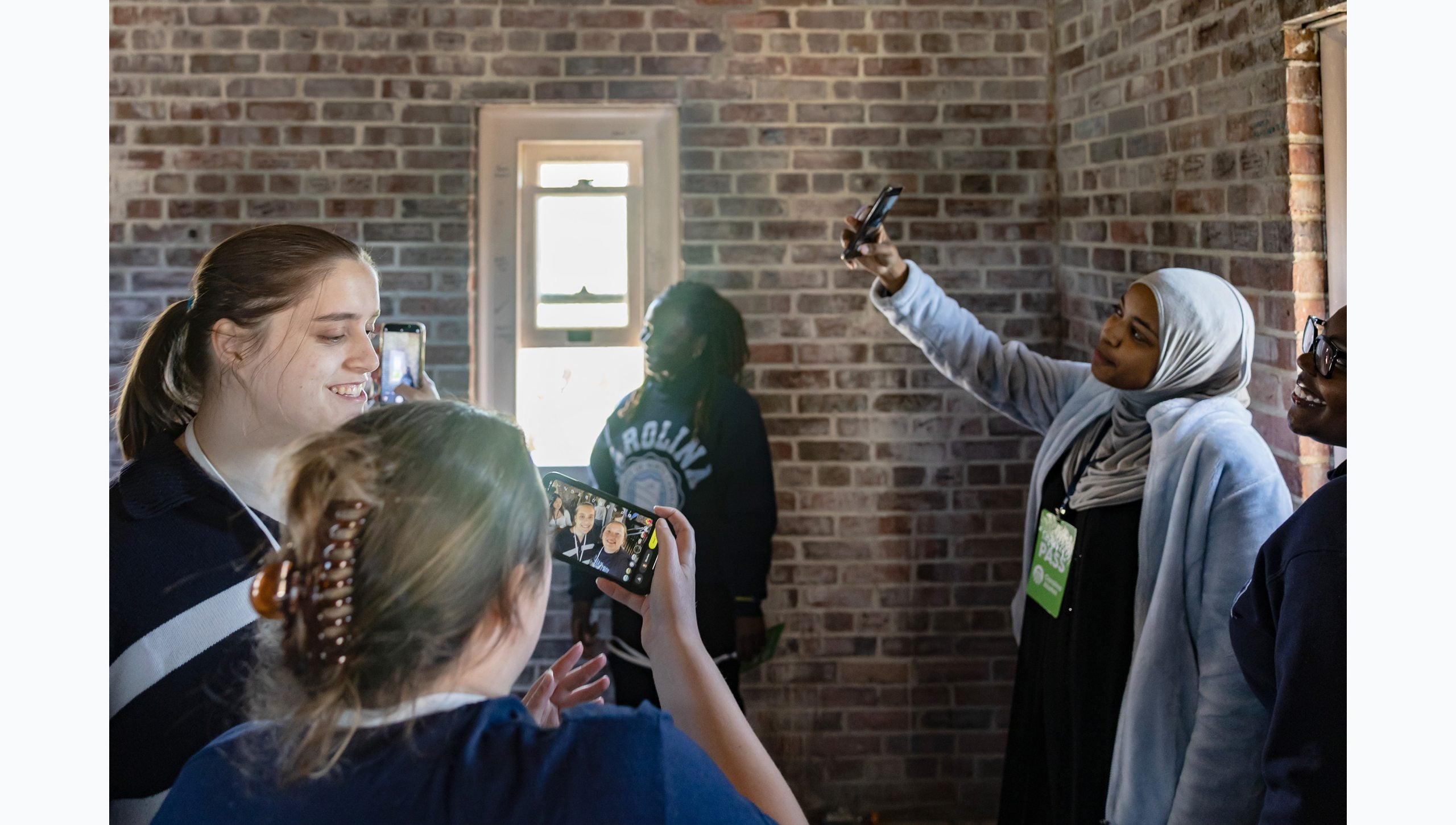UNC-Chapel Hill students inside the Morehead-Patterson Bell Tower taking photos with their phones, including selfies.
