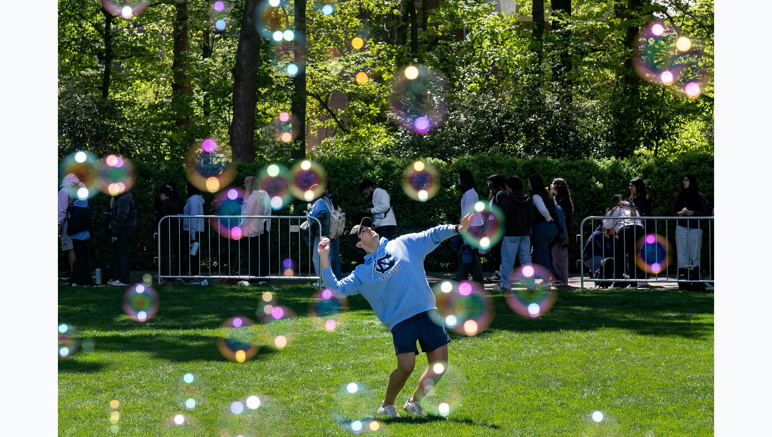 Bubles seen in the foreground as a UNC-Chapel Hill student is seen on a lawn throwing a ball.