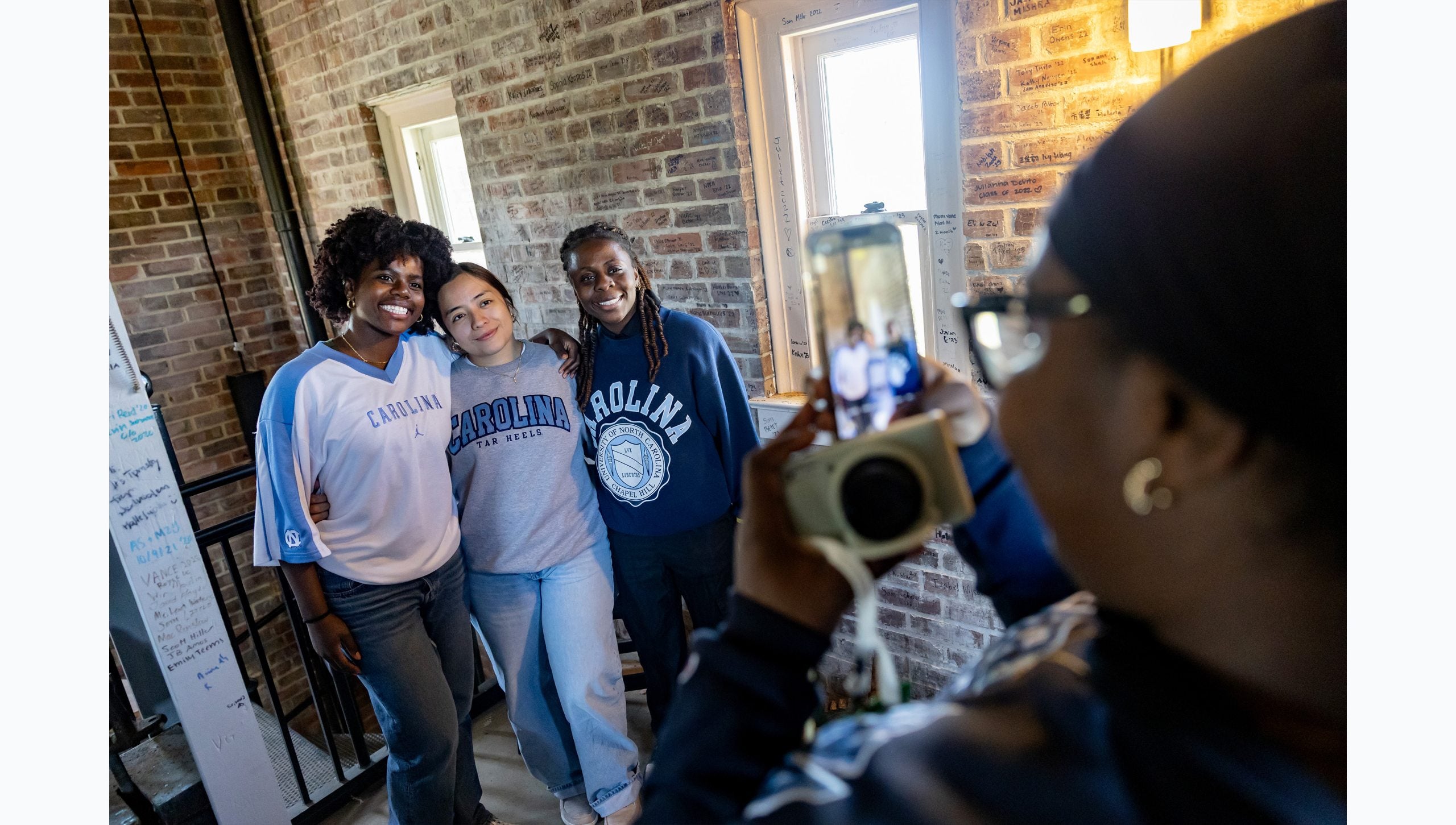 Three UNC-Chapel Hill students having the picture taken by another student inside the Morehead-Patterson Bell Tower.