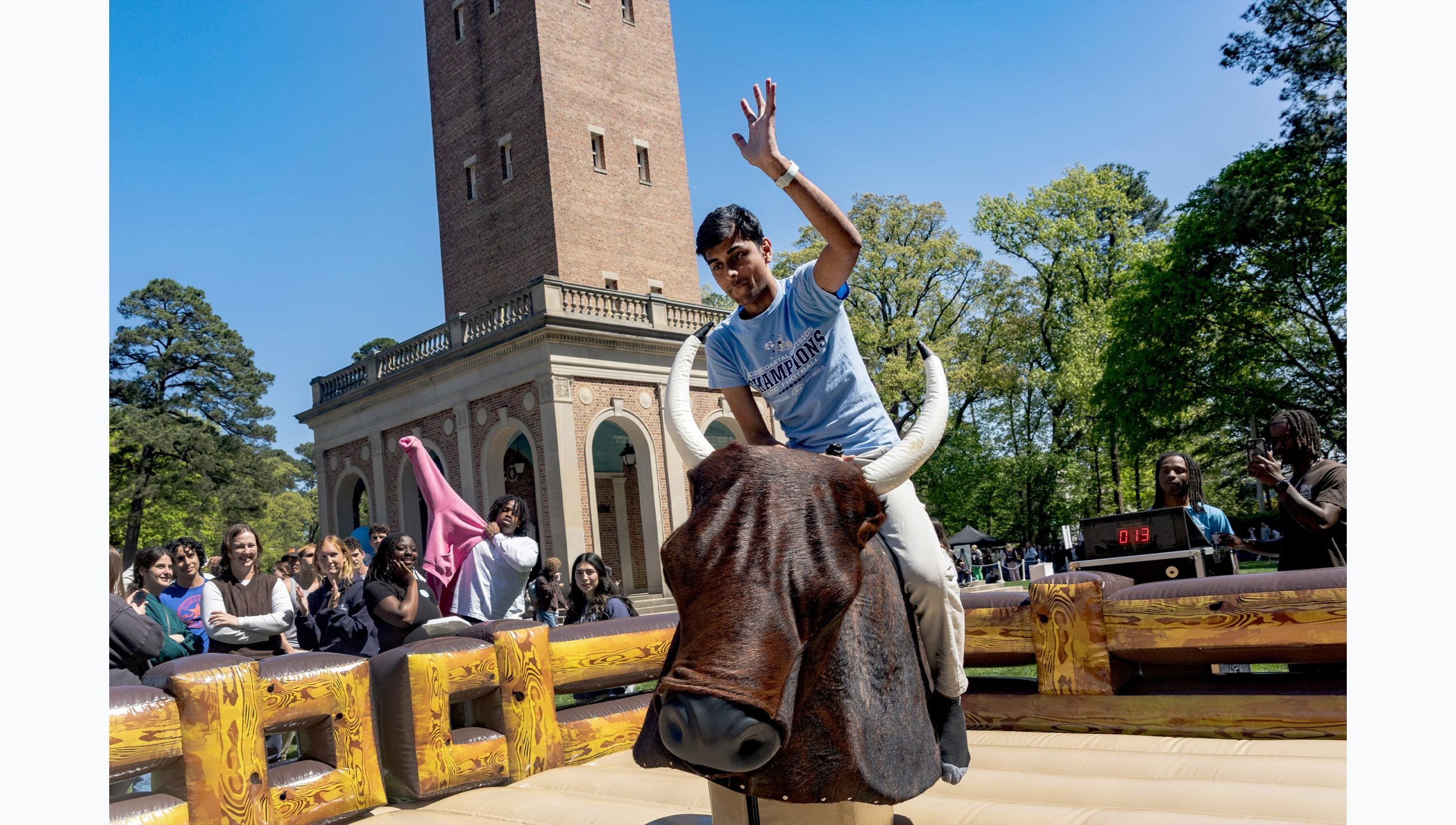 UNC-Chapel Hill riding a mechanical bull near the Bell Tower.