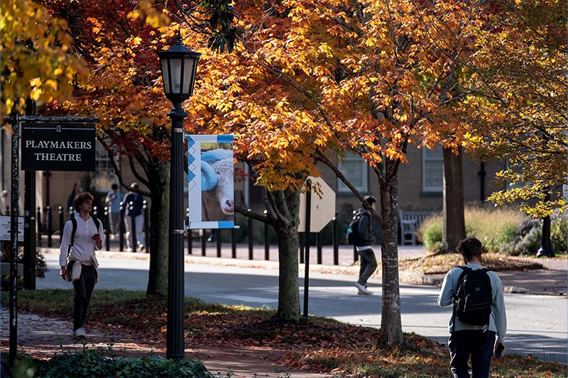 Students walk by PlayMakers Theatre and a 