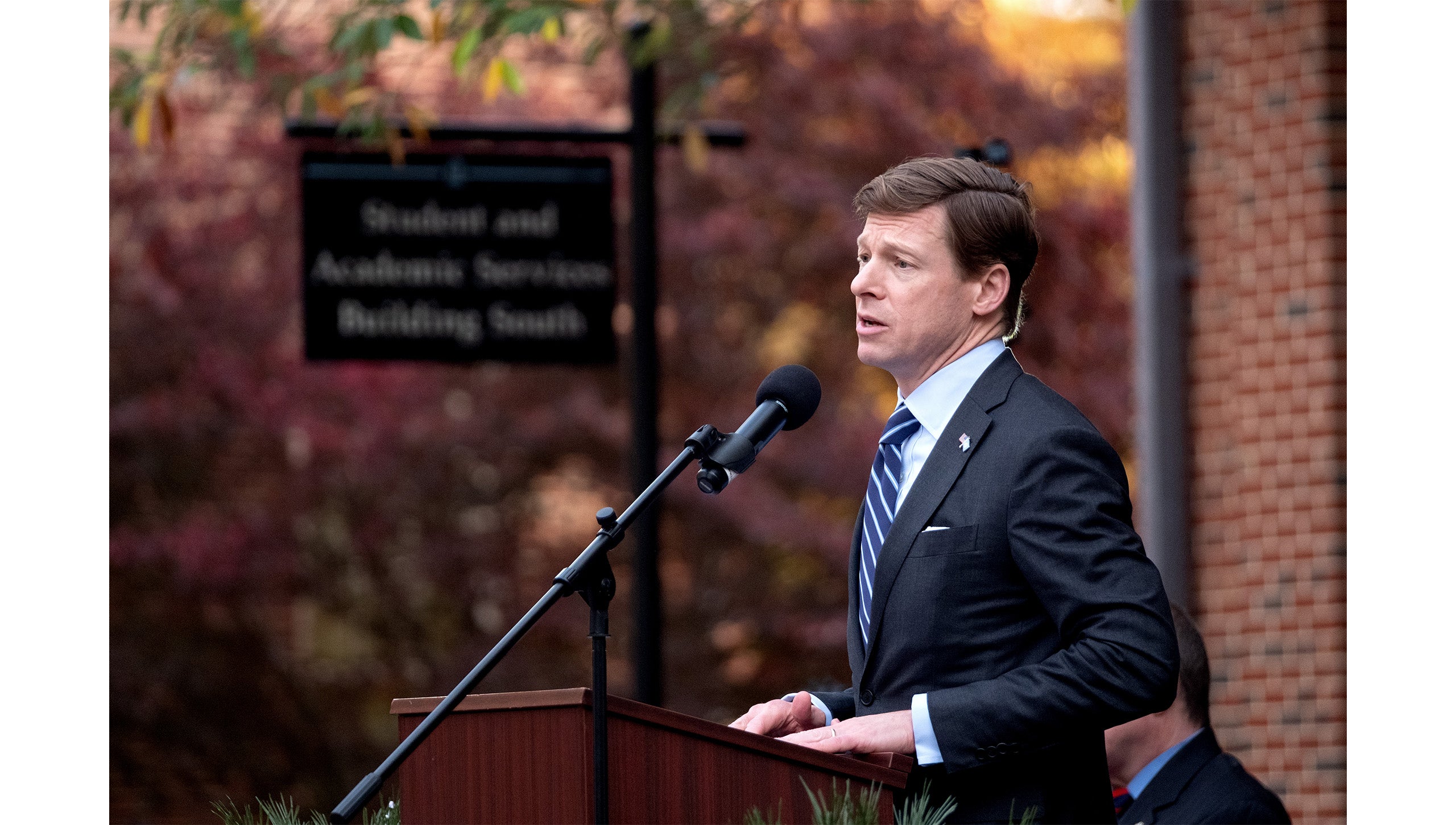 UNC-Chapel Hill Chancellor Lee H. Roberts speaking into microphone at a podium at the grand opening of the Military and Veteran Student Success Center.
