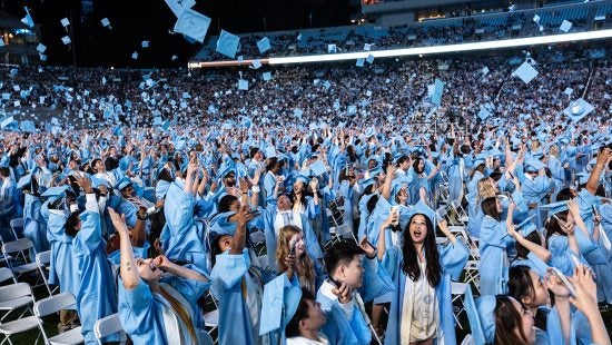 Carolina graduates toss their caps during 2025 Spring Commencement at Kenan Stadium.