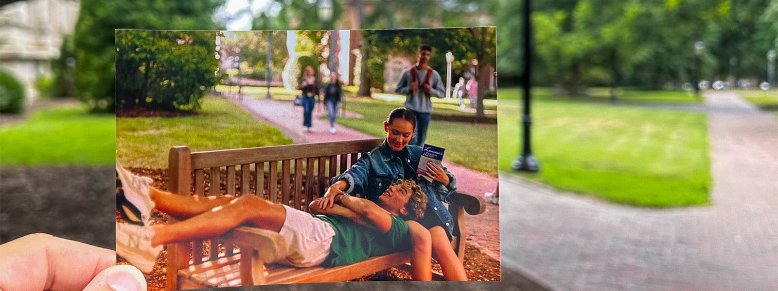 Hand holding a photo of two characters from 