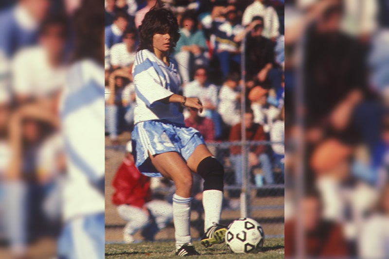 Mia Hamm playing for the UNC women's soccer team and preparing to make a pass.