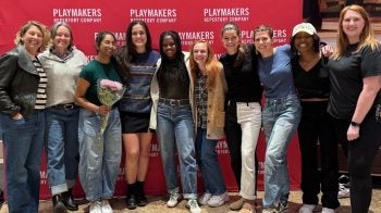 Actors and athletes posing in front of playmakers sign.