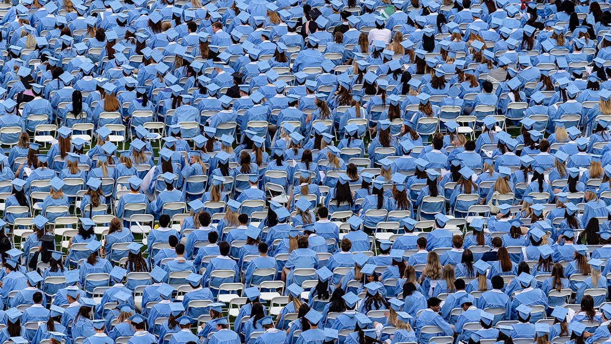 Graduates sitting on the field at Kenan Stadium during 2024 Spring Commencement.