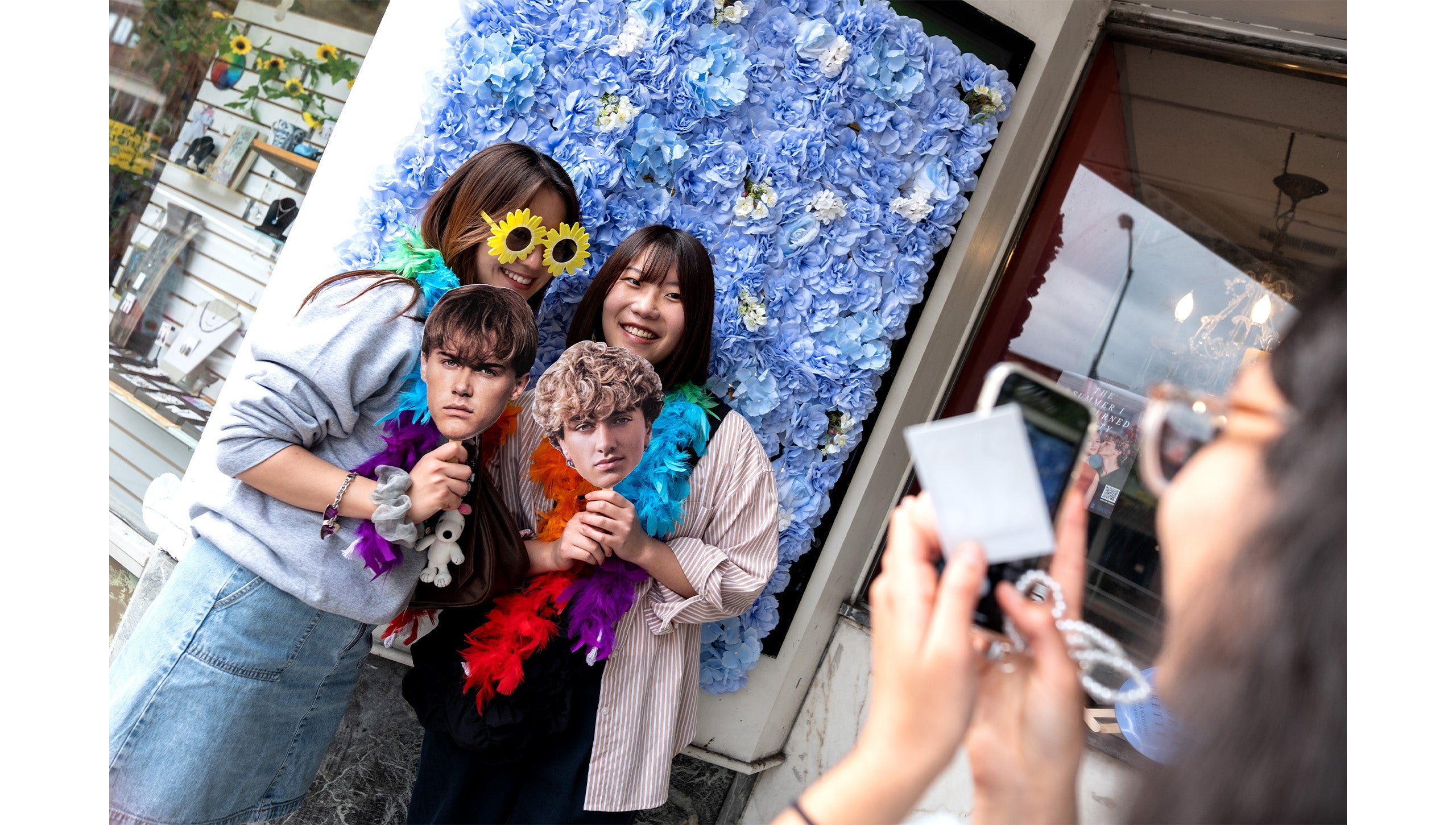 Two UNC-Chapel Hill students holding up head cutouts of characters from “The Summer I Turned Pretty” outside the Varsity Theatre.