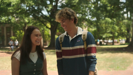 Lola Tung (Belly) and Gavin Casalegno (Jeremiah) smiling at each other on McCorkle Place, with Graham Memorial Hall visible in the background.