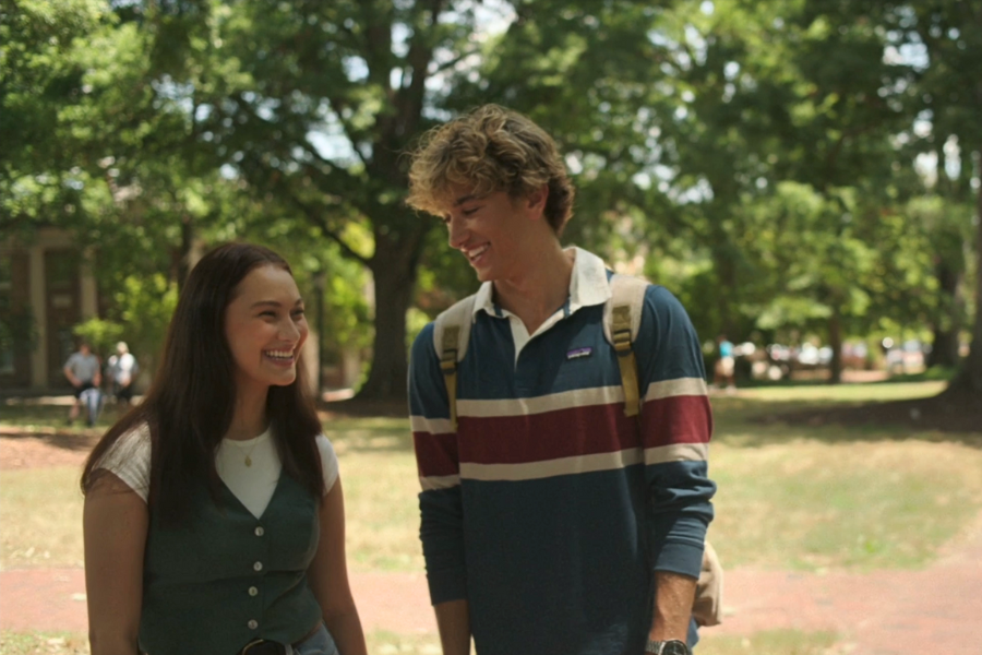 Lola Tung (Belly) and Gavin Casalegno (Jeremiah) smiling at each other on McCorkle Place, with Graham Memorial Hall visible in the background.