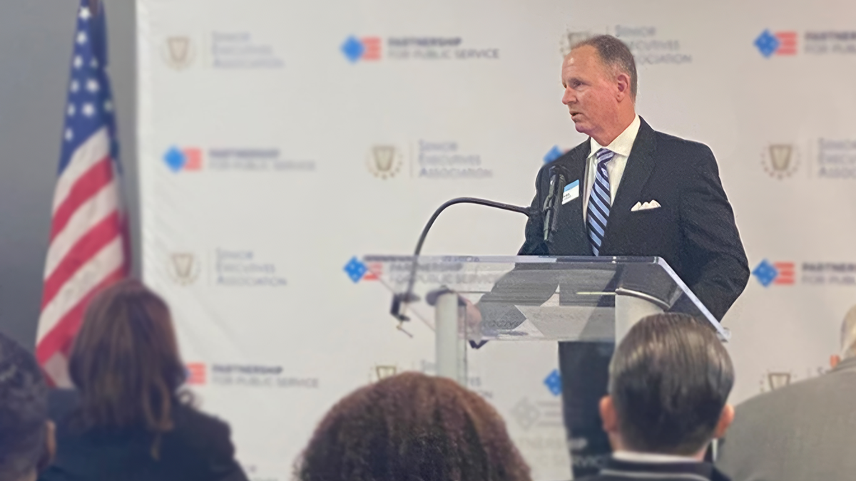 Kirk Lawrence, who leads UNC Executive Development's Government and Defense Sector program, talks at a pedestal to a group of people