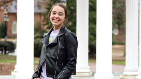 Sunita Agarwala wearing a t-shirt and leather jacket underneath the Old Well.