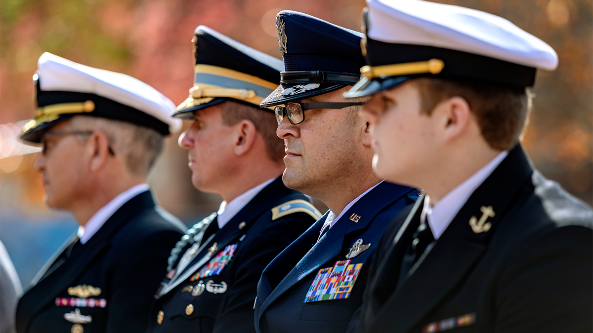 Four individuals in various military uniforms.
