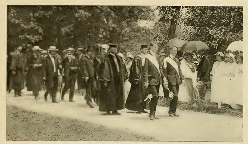 An archival photo from 1914 of student marshals leading a procession of student.