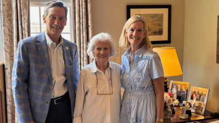 Three people, including Pepper Dowd in the middle, posing for a group photo.