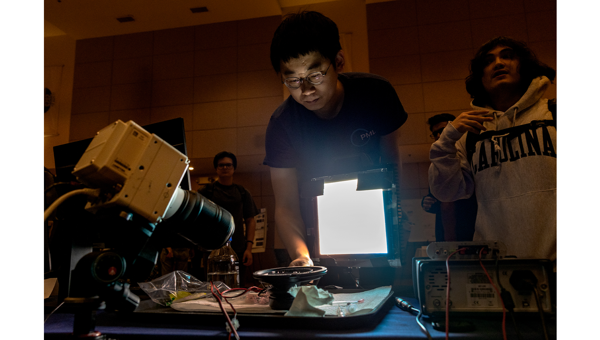 Students at the Physical Mathematics Laboratory table prepare for a demonstration.